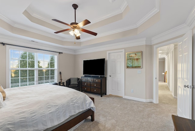 carpeted bedroom with ornamental molding, ceiling fan, and a tray ceiling