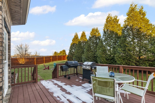 wooden deck featuring a yard and a grill