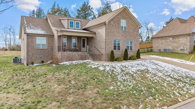 view of front facade featuring a front yard, central AC, and a porch