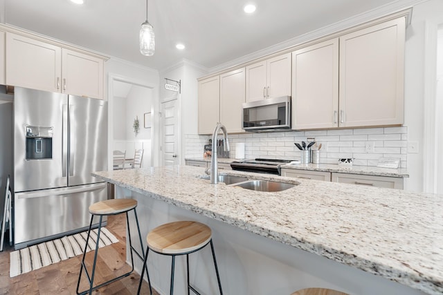 kitchen with stainless steel appliances, sink, pendant lighting, and light stone countertops