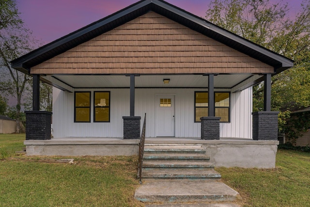 view of front of property featuring a porch and a lawn