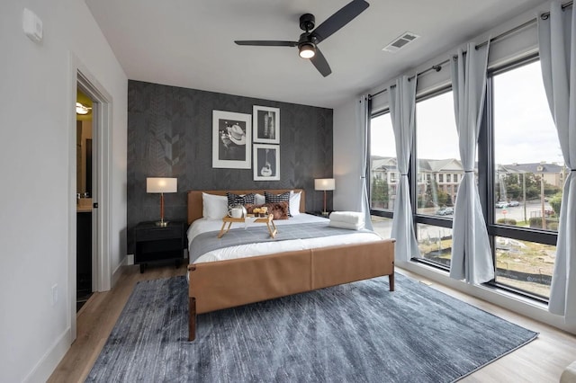 bedroom with ceiling fan, access to outside, and hardwood / wood-style floors