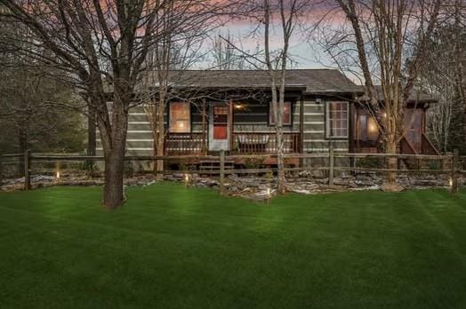 back house at dusk featuring a yard