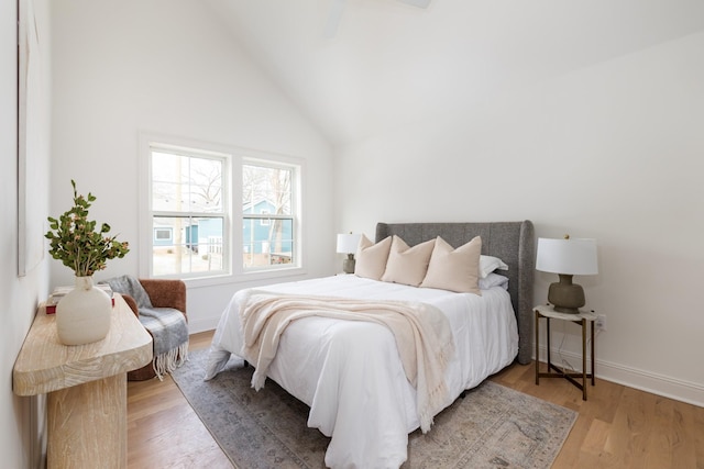 bedroom featuring light hardwood / wood-style floors and high vaulted ceiling