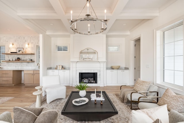 living room featuring an inviting chandelier, beam ceiling, and coffered ceiling