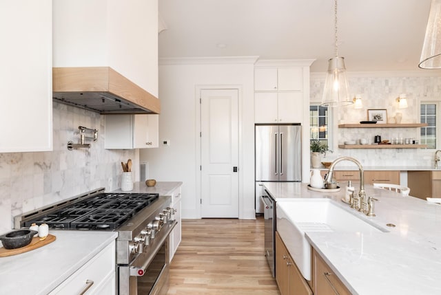 kitchen with white cabinets, pendant lighting, high end appliances, and premium range hood