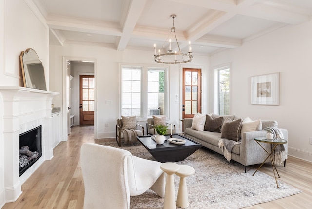 living room featuring plenty of natural light, light hardwood / wood-style floors, a notable chandelier, and beam ceiling