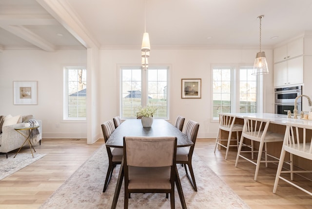 dining space with ornamental molding, light hardwood / wood-style flooring, and beam ceiling