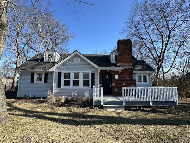 view of front of home with a deck and a front lawn