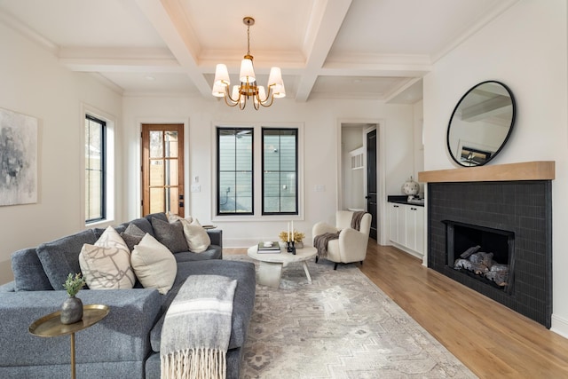 living room featuring coffered ceiling, wood-type flooring, an inviting chandelier, and beamed ceiling