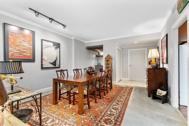 dining area with a textured ceiling, rail lighting, and ornamental molding