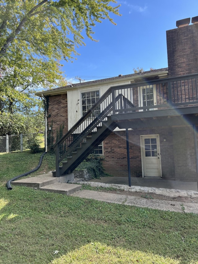 back of house with a yard, a deck, and a patio area