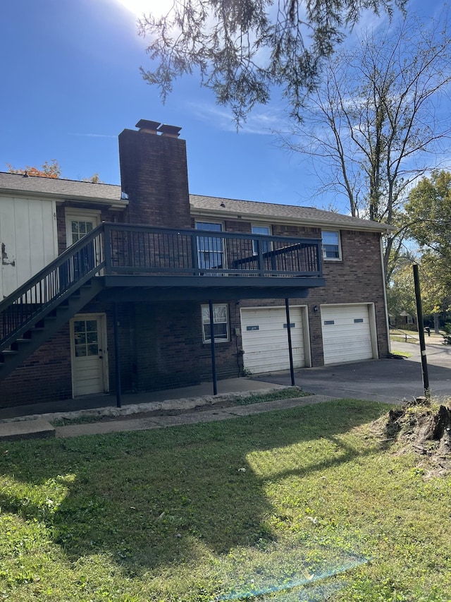 back of house with a garage, a wooden deck, and a lawn