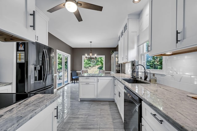 kitchen with tasteful backsplash, black appliances, light stone countertops, white cabinets, and sink