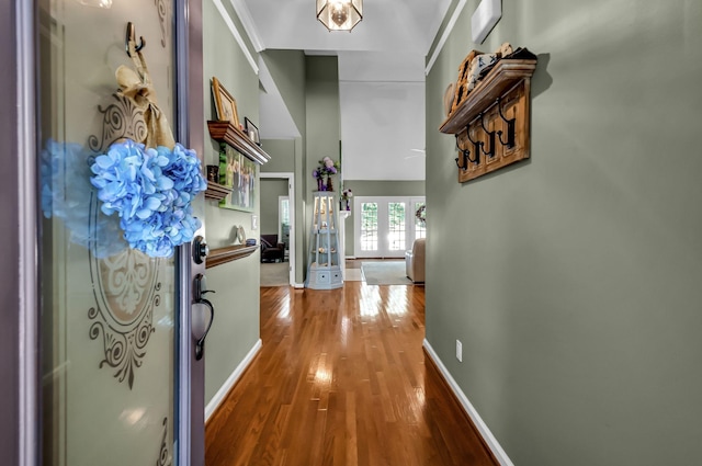 corridor with hardwood / wood-style flooring and crown molding