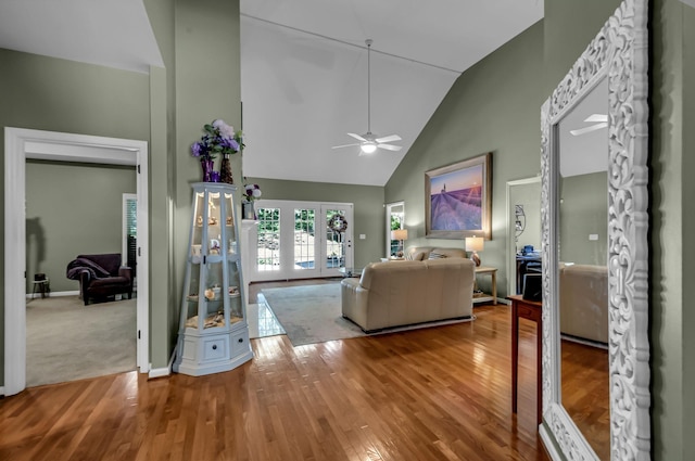 living room with hardwood / wood-style flooring, high vaulted ceiling, and ceiling fan