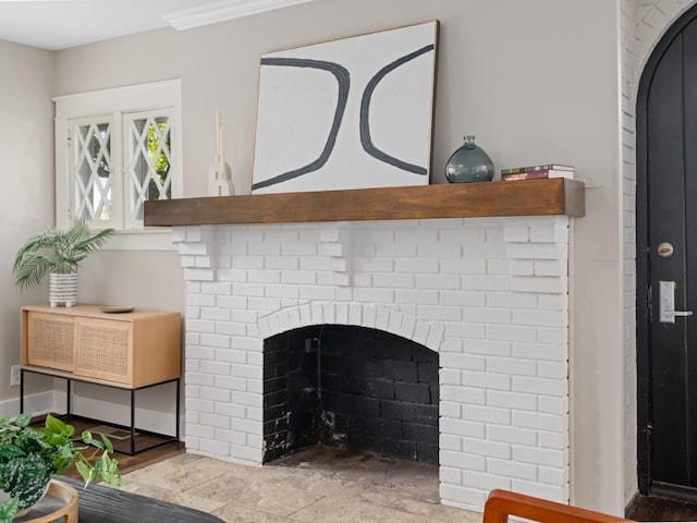 interior details featuring a brick fireplace and ornamental molding