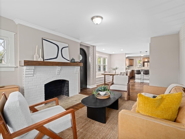 living room featuring light hardwood / wood-style floors, ornamental molding, and a fireplace