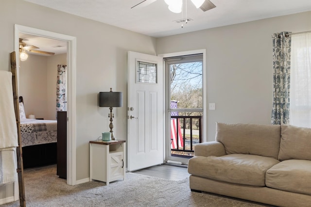 carpeted foyer entrance with ceiling fan and plenty of natural light