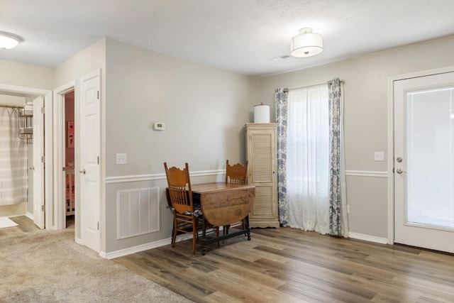 dining room featuring a textured ceiling and wood-type flooring