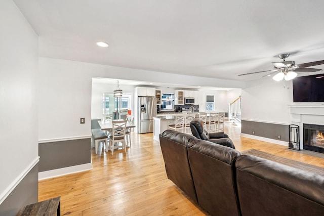 living room featuring ceiling fan and light hardwood / wood-style flooring