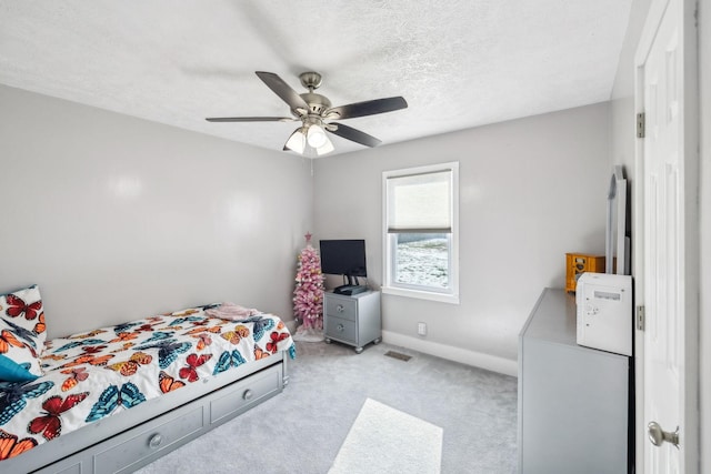 carpeted bedroom with a textured ceiling and ceiling fan