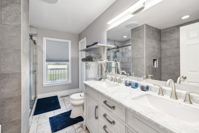 bathroom featuring a shower with door, vanity, and toilet