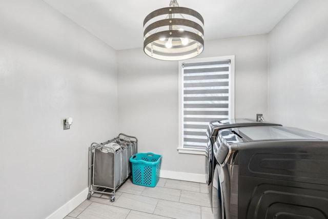 laundry room featuring a chandelier and washing machine and clothes dryer