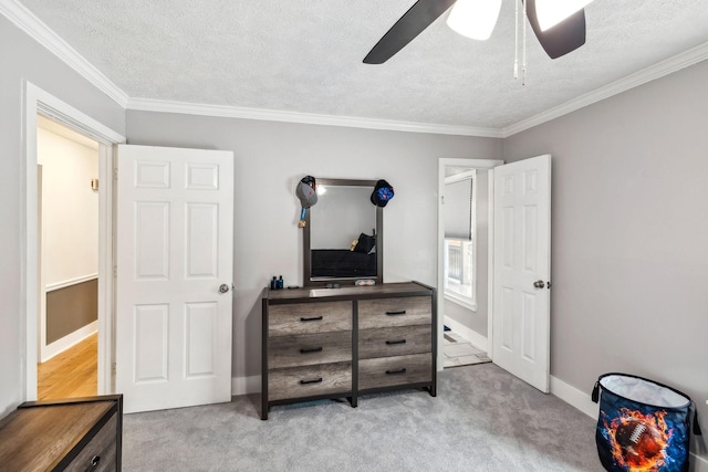 carpeted bedroom with a textured ceiling, ceiling fan, and ornamental molding