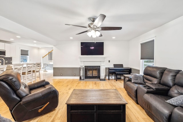 living room with light wood-type flooring and ceiling fan