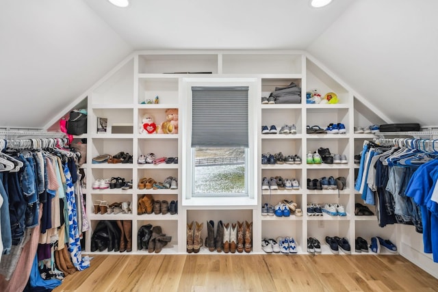 walk in closet featuring wood-type flooring and vaulted ceiling