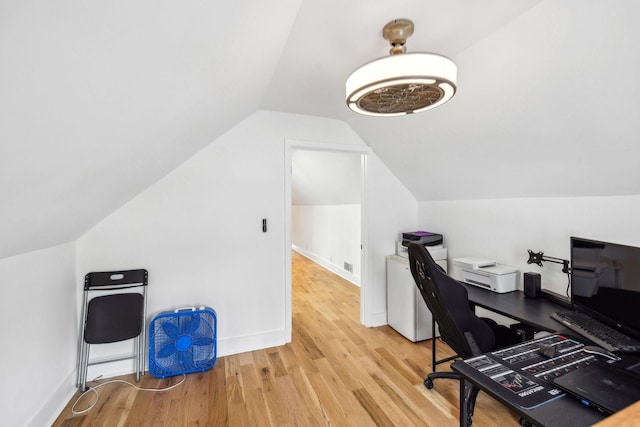 home office with vaulted ceiling and light hardwood / wood-style flooring