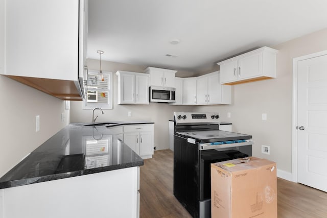 kitchen with sink, dark wood-type flooring, appliances with stainless steel finishes, and white cabinetry