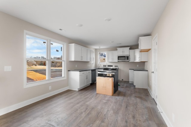 kitchen featuring light hardwood / wood-style flooring, stainless steel appliances, a kitchen island, white cabinetry, and sink