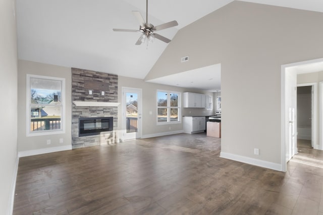 unfurnished living room featuring ceiling fan, dark wood-type flooring, high vaulted ceiling, and a fireplace