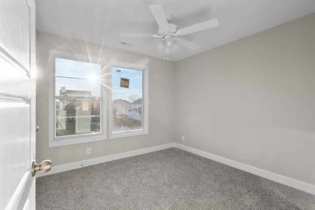 carpeted empty room with ceiling fan and plenty of natural light