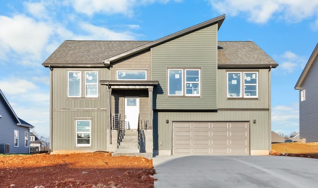 view of front of property with a garage and central AC