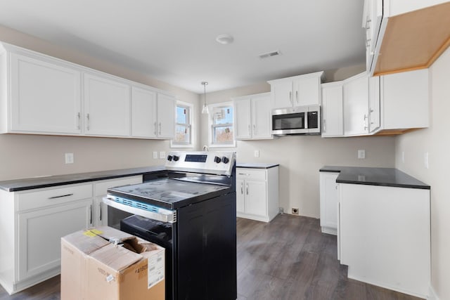 kitchen with appliances with stainless steel finishes, a center island, dark hardwood / wood-style floors, white cabinetry, and decorative light fixtures