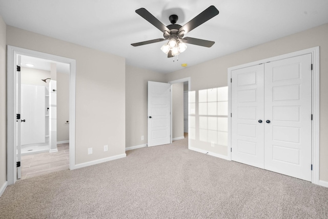 unfurnished bedroom featuring ceiling fan, light colored carpet, a closet, and connected bathroom