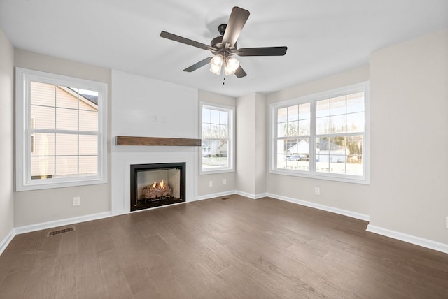 unfurnished living room featuring ceiling fan and dark hardwood / wood-style flooring