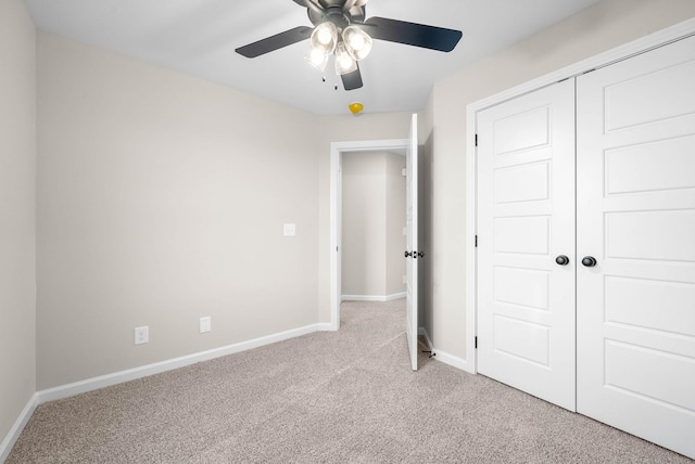 unfurnished bedroom with ceiling fan, light colored carpet, and a closet