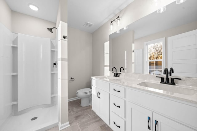 bathroom with toilet, a shower, and vanity