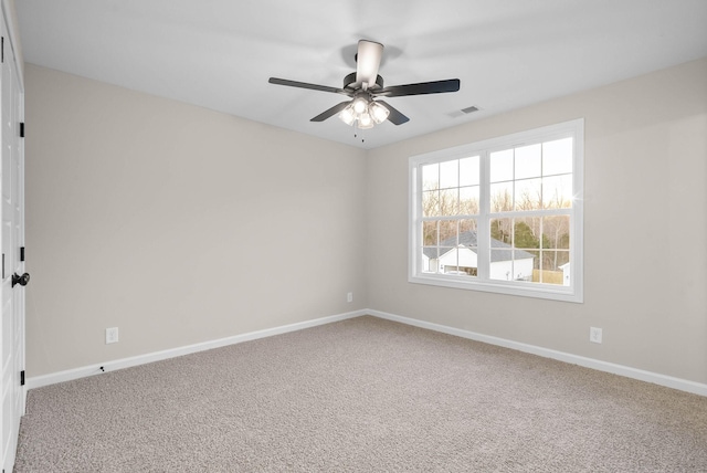 spare room with ceiling fan and carpet