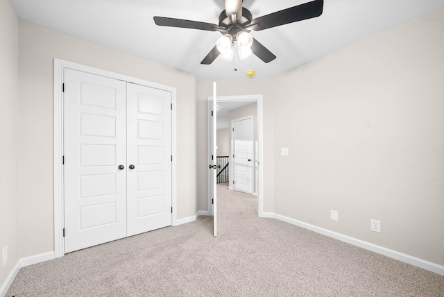 unfurnished bedroom with ceiling fan, a closet, and light carpet