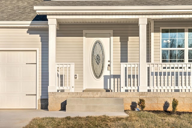 doorway to property with a porch and a garage