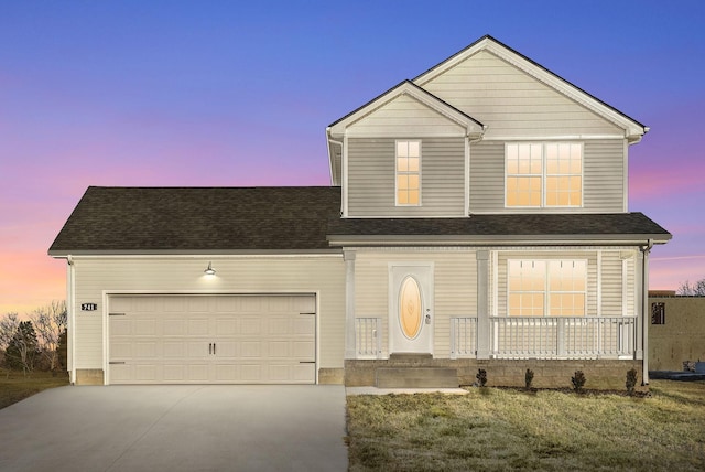 view of front of home with a garage, a yard, and a porch