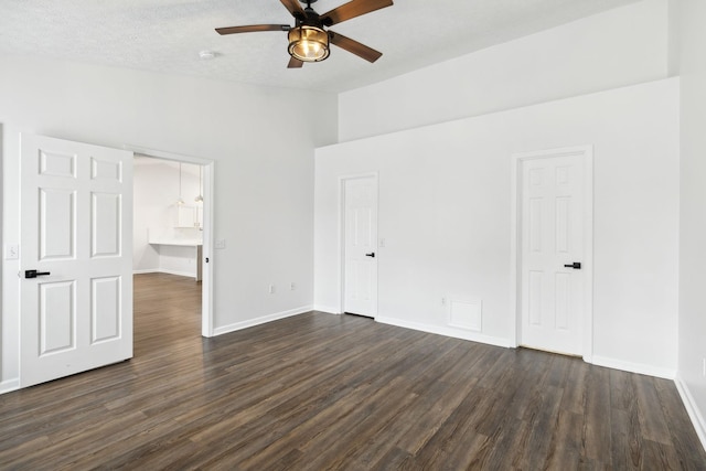 unfurnished bedroom featuring dark wood-type flooring, a textured ceiling, and ceiling fan