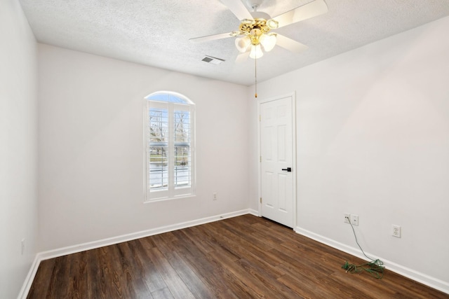 empty room with a textured ceiling, ceiling fan, and dark hardwood / wood-style floors