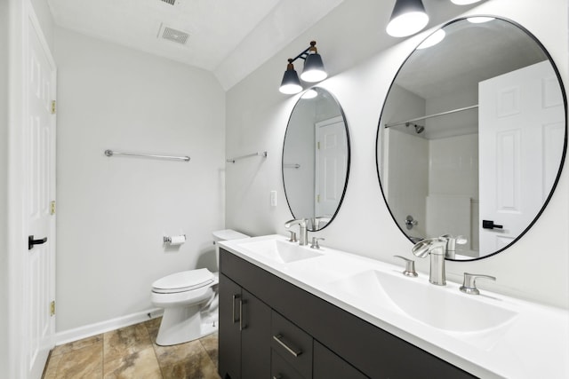 bathroom featuring toilet, vanity, and lofted ceiling