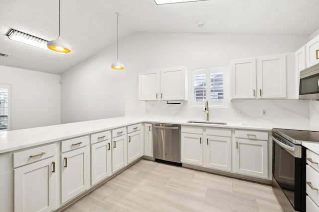 kitchen featuring appliances with stainless steel finishes, white cabinetry, pendant lighting, and sink